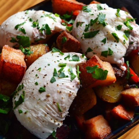Three poached eggs over a bed of crispy, fried potatoes