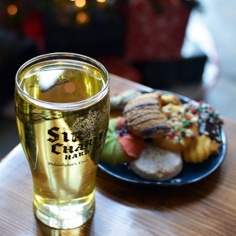 A glass of Sir Charles Hard Cider, with a plate of Christmas cookies in the background