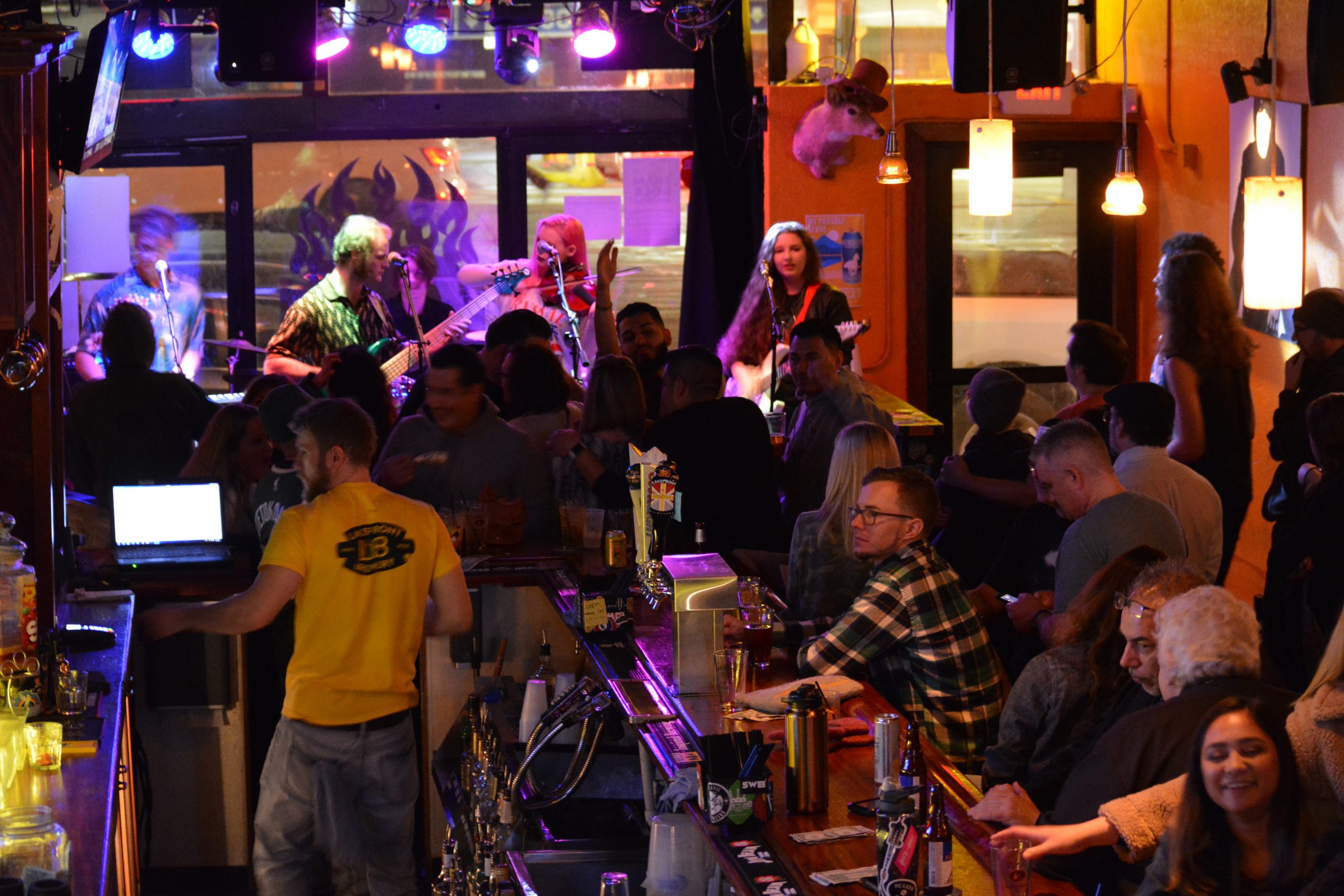 The band in the background with the bar and the crowd in the foreground