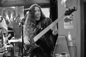 Black and white image of Elly Bird playing bass guitar
